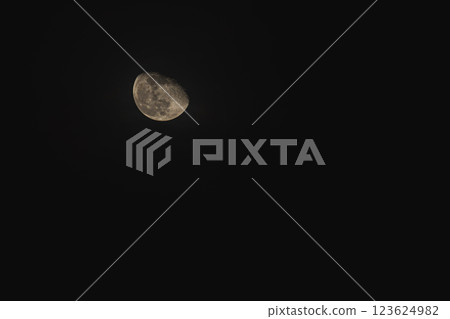 A luminous crescent moon illuminating a tranquil night sky above 123624982