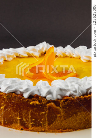 Delightful orange cake topped with cream and citrus slices for dessert lovers 123625006
