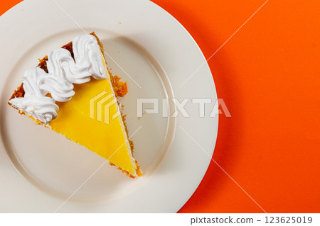 Delicious citrus tart served with fluffy whipped cream on a bright plate 123625019