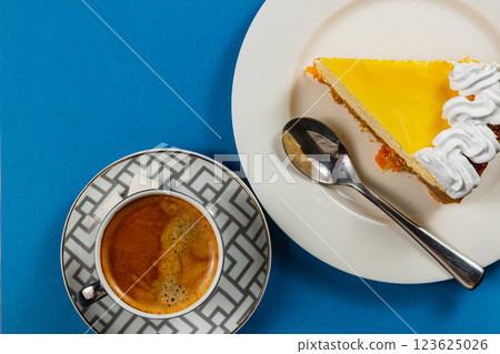 Enjoying a delightful lemon tart with a rich espresso on a bright blue table 123625026