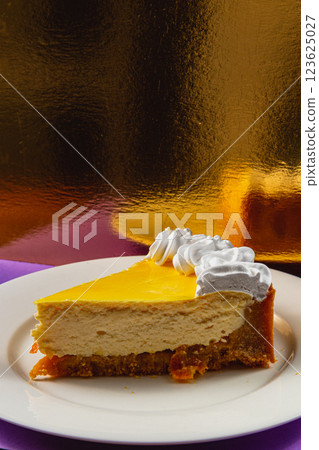 Savoring a delightful slice of creamy mango cheesecake on a vibrant background 123625027