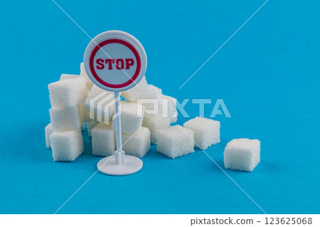 Sugar cubes stacked beside a stop sign emphasizing health awareness Sugar cubes stacked beside a stop sign emphasizing health awareness 123625068