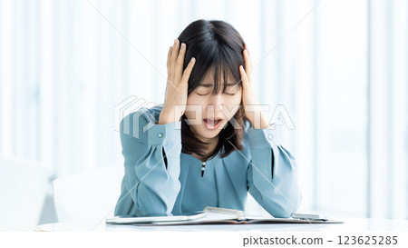 A woman/businesswoman holding her head in worry 123625285