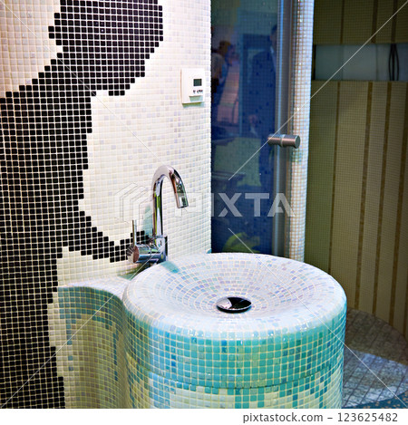 Faucet and sink in interior with small tiles 123625482