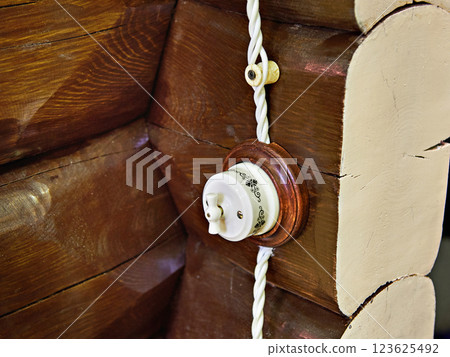 Retro light switch on wall of logs Retro light switch on wall of logs 123625492