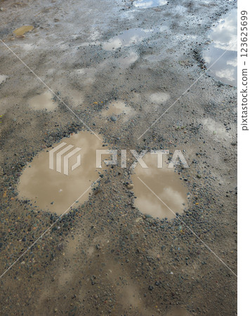 dirty puddles in a potholes on an old road dirty puddles in a potholes on an old road 123625699