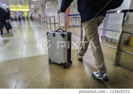 Traveler with Rolling Suitcase in Airport 123626252