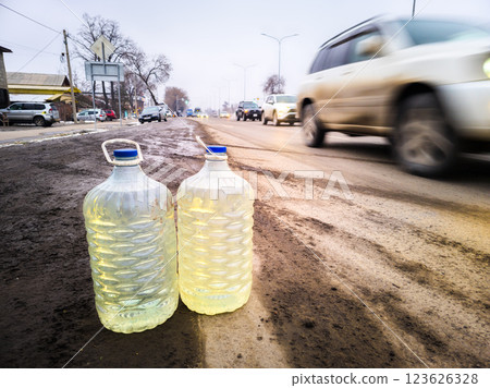 plastic bottles with contraband gasoline on the side of the road, the concept of street petrol vendors in Bishkek, Kyrgyzstan plastic bottles with contraband gasoline on the side of the road, the concept of street petrol vendors in Bishkek, Kyrgyzstan 123626328
