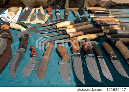 Knives on the counter of a craftsman. Sale of knives. A large selection of knives of different shapes and sizes. Knives on the counter of a craftsman. Sale of knives. A large selection of knives of different shapes and sizes. 123626417