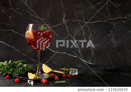 Royal lemonade cocktail with tequila, gin, rum, vodka, ice and fresh raspberries, bar and party concept, advertising card for restaurant and cafe, black background, selective focus. Royal lemonade cocktail with tequila, gin, rum, vodka, ice and fresh raspberries, bar and party concept, advertising card for restaurant and cafe, black background, selective focus. 123626635