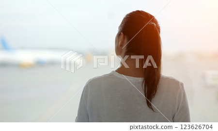 Woman observes process of aircraft movement on airfield Woman observes process of aircraft movement on airfield 123626704