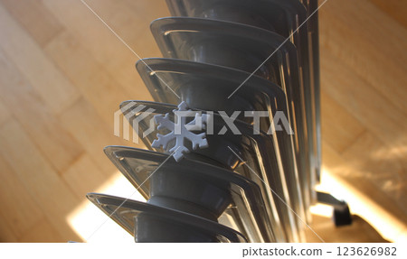 Artificial Snowflake On The Oil Filled Heater On A Wooden Floor In A Cold Room. Heat Saving Technologies and Home Heating Stock Image Artificial Snowflake On The Oil Filled Heater On A Wooden Floor In A Cold Room. Heat Saving Technologies and Home Heating Stock Image 123626982