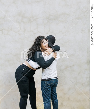 Teenage couple embracing happily outdoor. Two teenage friends embracing fraternally, Young happy couple embracing outdoors Teenage couple embracing happily outdoor. Two teenage friends embracing fraternally, Young happy couple embracing outdoors 123627062