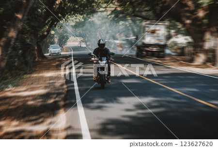 Motorcycle driver at full speed on the highway. Motorcyclist driving at high speed on the street Motorcycle driver at full speed on the highway. Motorcyclist driving at high speed on the street 123627620