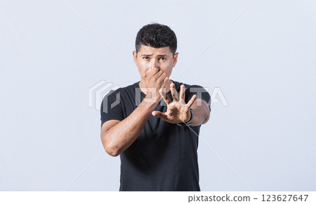 Annoyed man covering his nose, Confused unhappy man grabbing nose with fingers and stretching hand out feeling disgusted Annoyed man covering his nose, Confused unhappy man grabbing nose with fingers and stretching hand out feeling disgusted 123627647