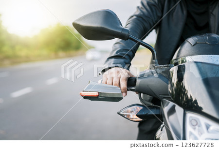 Close up of hands of biker on the handlebars of a motorcycle outdoors. Hands of a motorcyclist on the handlebars on the road. Motorbike speeding concept 123627728