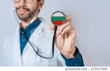 Doctor holding stethoscope with Bulgaria flag. Bulgaria health and care concept, Bulgaria flag on stethoscope 123627900