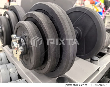 Weights arranged neatly in a fitness center for strength training enthusiasts Weights arranged neatly in a fitness center for strength training enthusiasts 123628026