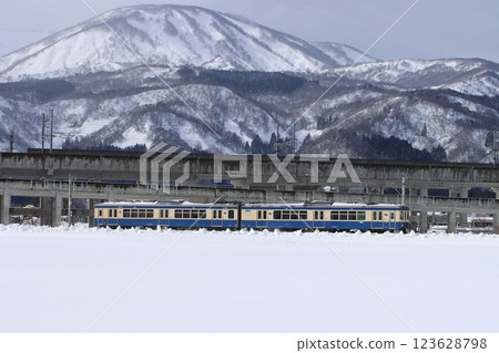 Echigo Tokimeki Railway ET127 series train (reprint wrapping) running with Mt. Myoko in the background in winter_2024/2/9 photo 123628798