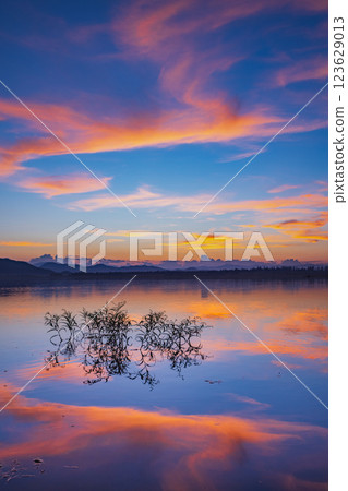 Landscape of mountains and lake at sunset and clouds reflected in the water. Landscape of mountains and lake at sunset and clouds reflected in the water. 123629013