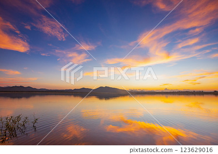 Landscape of mountains and lake at sunset and clouds reflected in the water. 123629016