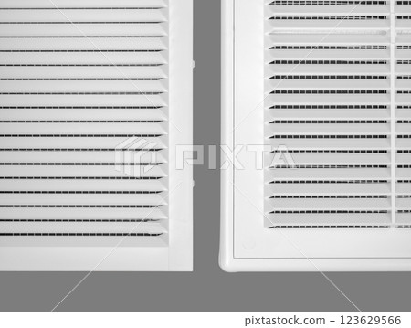 White ventilation grate on a gray background. Close-up. Material is plastic. White ventilation grate on a gray background. Close-up. Material is plastic. 123629566