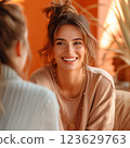 A woman with a smile on her face is sitting next to another woman. Therapy concept 123629763