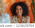 A woman with curly hair and glasses is smiling at the camera. Therapy concept 123629764