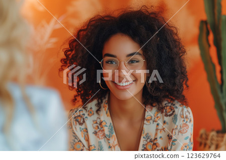 A woman with curly hair and glasses is smiling at the camera. Therapy concept A woman with curly hair and glasses is smiling at the camera. Therapy concept 123629764