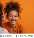 A woman with curly hair and glasses is smiling at the camera. Therapy concept 123629766