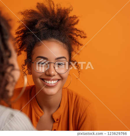 A woman with curly hair and glasses is smiling at the camera. Therapy concept A woman with curly hair and glasses is smiling at the camera. Therapy concept 123629766