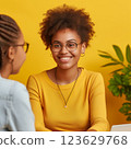 A woman wearing glasses and a yellow shirt is smiling at the camera. Therapy concept 123629768