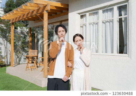 A couple thinking in front of their house 123630488