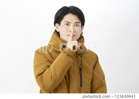 Man wearing down jacket, secret gesture, white background Man wearing down jacket, secret gesture, white background 123630641