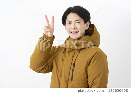 Man wearing down jacket, peace sign, white background 123630668