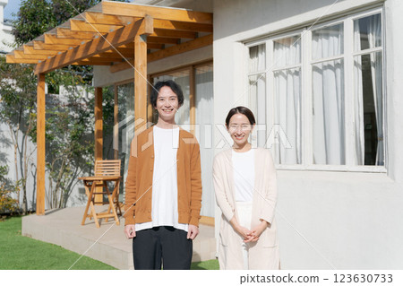 Smiling young couple in front of their home Smiling young couple in front of their home 123630733
