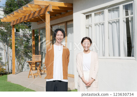 Smiling young couple in front of their home 123630734