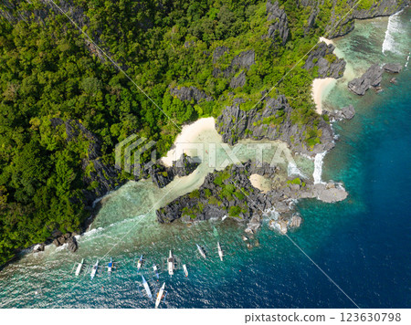 Sun reflection over the boats and clear sea water in Hidden Beach. Matinloc Island. El Nido, Philippines. 123630798