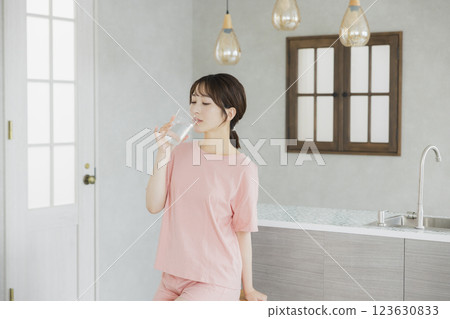 一個女人在廚房喝水 123630833