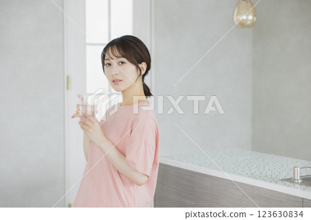 一個女人在廚房喝水 123630834