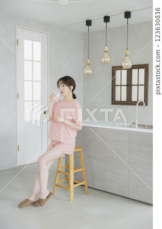 一個女人在廚房喝水 123630836