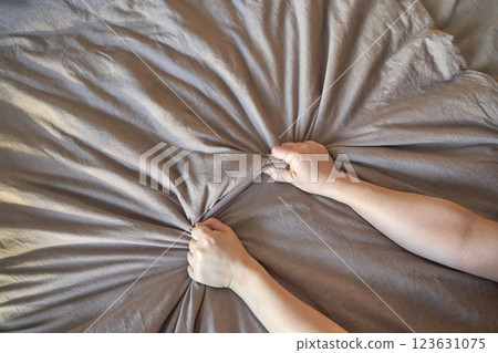 Close up of caucasian female hands gripping beige fabric with force and texture Close up of caucasian female hands gripping beige fabric with force and texture 123631075