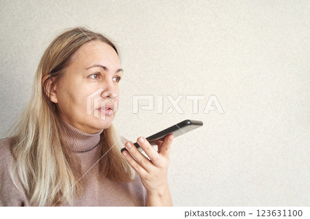 Caucasian female adult using smartphone voice command technology indoors 123631100