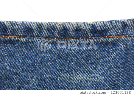 Close-up of blue denim fabric with orange stitching detail on jean material 123631128