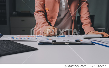 Cropped image of professional businesswoman working at her office via laptop, young female manager using portable computer device while sitting at modern loft, flare light, work process concept 123632244
