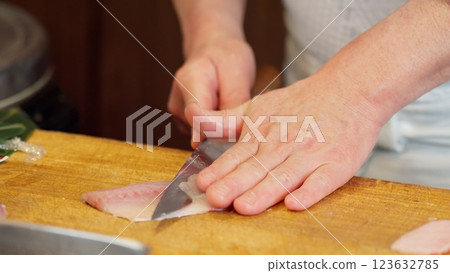 壽司師傅的手正在切海魴魚 壽司師傅的手正在切海魴魚 123632785