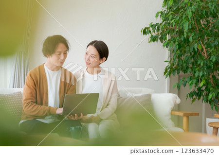 一對夫婦坐在沙發上看電腦 一對夫婦坐在沙發上看電腦 123633470