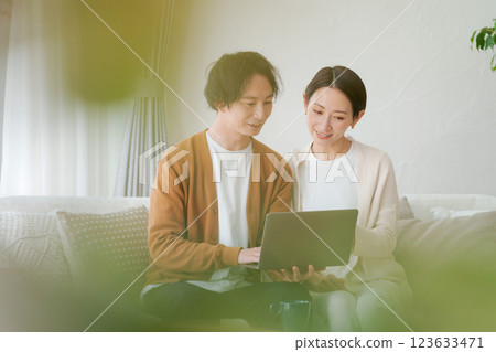 一對夫婦坐在沙發上看電腦 一對夫婦坐在沙發上看電腦 123633471