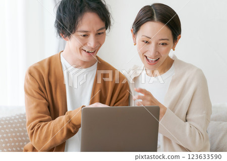 一對夫婦坐在沙發上看電腦 123633590