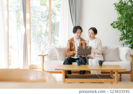 一對夫婦坐在沙發上看電腦 123633591